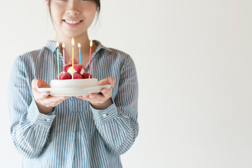 ケーキを持ち微笑む女性