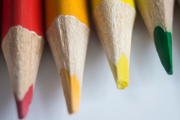 Colored pencils in rainbow colors close-up on white background