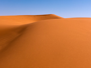Fototapeta na wymiar Die Wüste Sahara im Süden von Marokko. Sand und Dünen so weit das Auge reicht. Die Sandwüste wird auch Erg genannt.