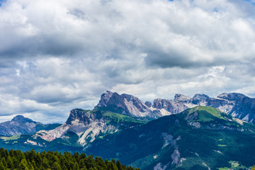 Fototapeta premium Alpe di Siusi, Seiser Alm with Sassolungo Langkofel Dolomite, a view of a large mountain in the background