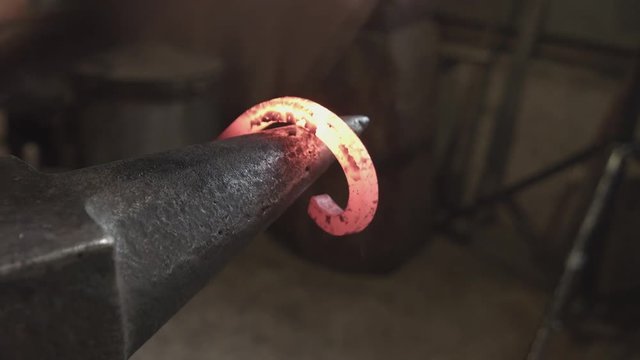 Blacksmith forges iron in fire