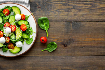 Vegetarian meal. Fresh vegetable salad on dark wooden background top view space for text