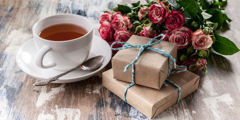 Banner. Roses, gifts, a cup of tea on a wooden background. Valentine's day concept