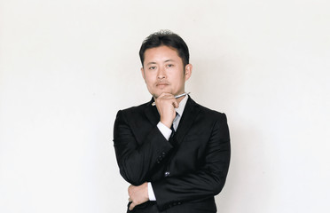 young business man thinking with holding pen.