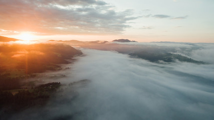 Aerial view of golden sunlight at sunrise with fog covered city town at the summer seasons.