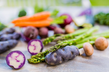 Raw and fresh spring vegetables on a wooden background.