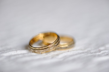 dos anillos de boda de oro sobre superficie blanca