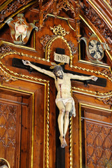 Cruz y Cristo sobre retablo de madera con las iniciales INRI encima