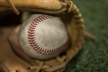 Closeup of baseball in glove on turf