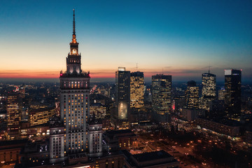 Aerial view of the business center of Warsaw: Palace of Science and Culture and skyscrapers in the evening - obrazy, fototapety, plakaty