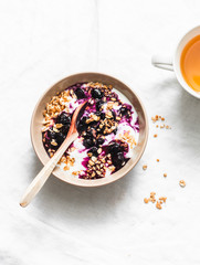 Granola, blueberry sauce greek yogurt  and green tea on light background, top view. Healthy breakfast concept