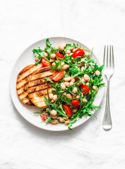 White beans, arugula, cherry tomatoes salad - delicious brunch, snack on a light background, top view