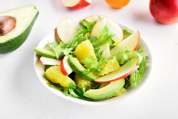 Salad with red apples, avocado, orange slices