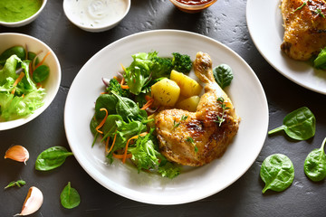 Grilled chicken leg with potato and green salad