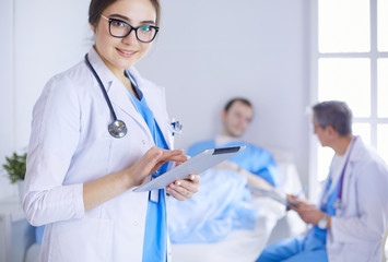 Female doctor using tablet computer in hospital lobby