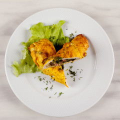 Baked stuffed chicken roll with green salad.