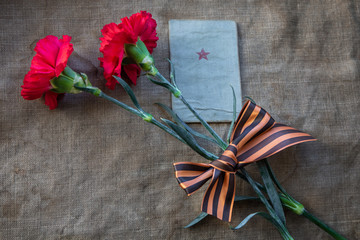 The red carnation, the soldier’s book, George ribbon on the canvas. Close-up. May 9.