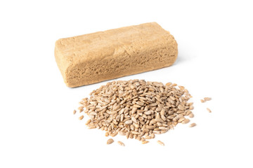Sunflower halva and seeds on dark wooden background.