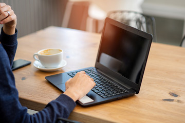 hand prints coffee in a laptop cup in a cafe
