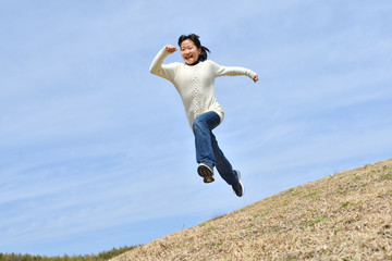 Obraz premium Japanese girl jumping in the blue sky