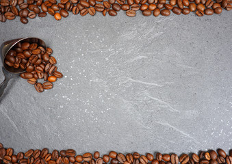 Coffee beans on grey kitchen table top view with copyspace for your text