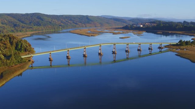 Aerial view at the golden hour of the Cruces River when it joins with the Valdivia River