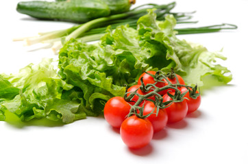 Tasty and ripe vegetables on white table.Ingredients for salad.Tomatoes,lettuce,cucumber and green onion