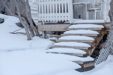 Snow covered on wooden stairs house
