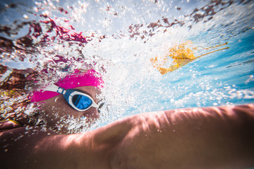 Close up wide angle photo of a female swimmer underwater in a swimming pool