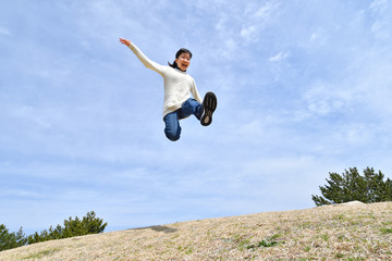 Japanese girl jumping in the blue sky