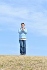 Japanese elementary school girl clapping in the blue sky