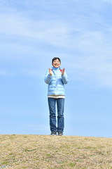 Japanese elementary school girl clapping in the blue sky