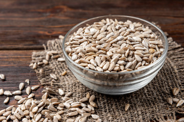 Sunflower seeds on dark wooden background.