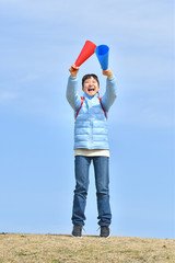 Japanese elementary school girl cheering with megaphone in the blue sky