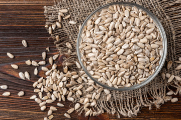 Sunflower seeds on dark wooden background.
