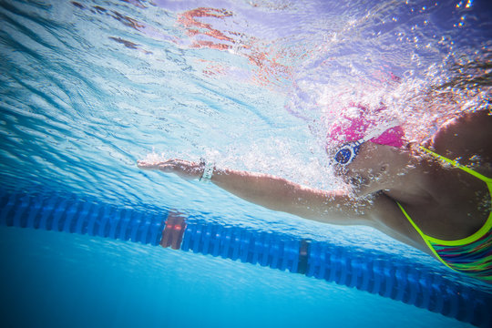 Close up wide angle photo of a female swimmer underwater in a swimming pool