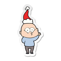 sticker cartoon of a bald man staring wearing santa hat