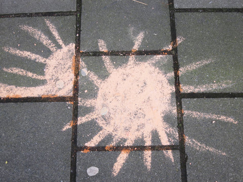 sun drawn on hte sidewalk with orange colored chalk