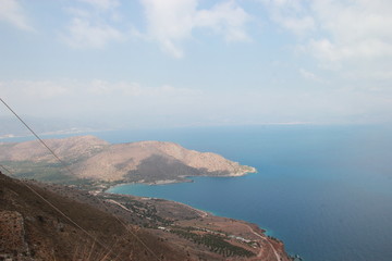 A small island in the sea with blue water off the coast of Crete