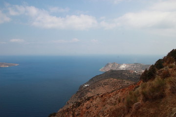 A small island in the sea with blue water off the coast of Crete