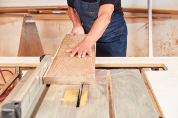 Schreiner sägt ein Holz Brett an der Kreissäge