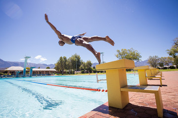 Close up image of a swimmer diving into a swimming pool during training for a big swimming race