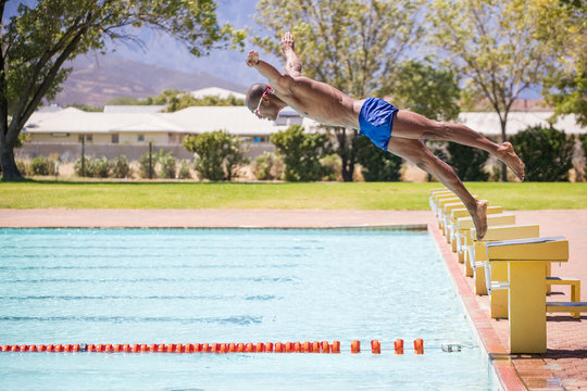 Close up image of a swimmer diving into a swimming pool during training for a big swimming race