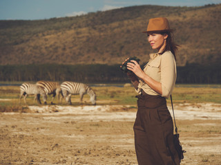 Beautiful woman with binoculars at savanna in Kenya