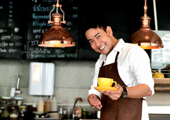 Asian barista serving yellow coffee mug, lifestyle concept.