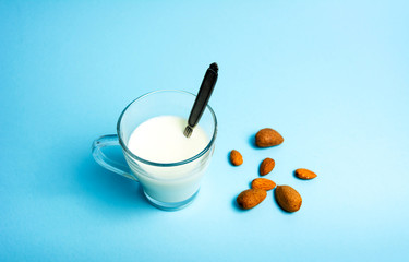 Almond milk in a glass against blue background