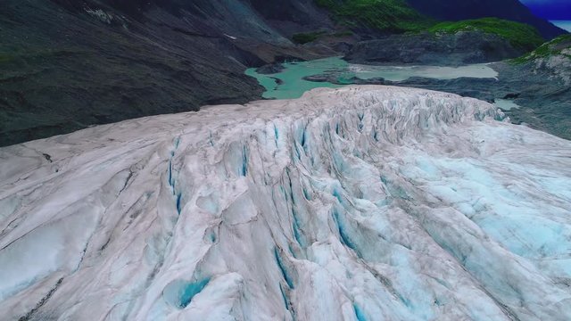 Beautiful aerial of the mouth of a blue iced glacier.