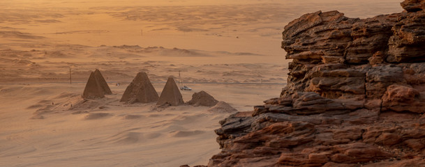 Background with the pyramids of Karima, Sudan, Africa, and the corner of the holy mountain Jebal Barkal in the foreground. - obrazy, fototapety, plakaty