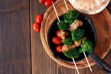 Vegan kebabs with seitan and broccoli on wooden skewers.