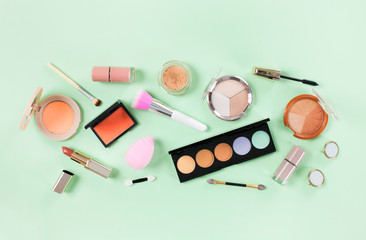 Makeup products on a soft green background